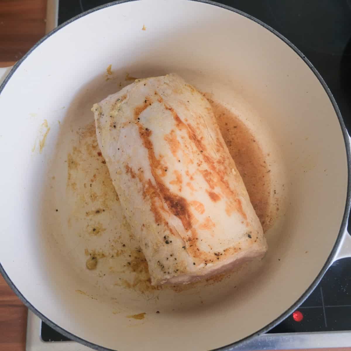Searing the pork loin from all sides.