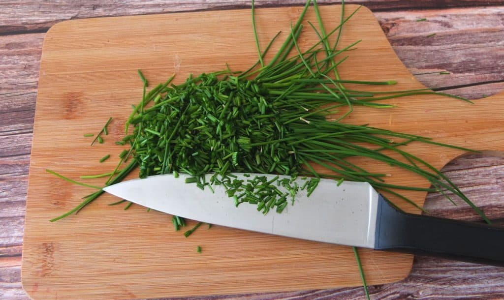 Chopping board with chives and a knife 