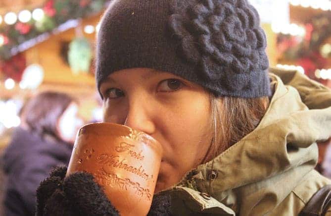 A girl drinken mulled apple wine at a German Christmas Market 