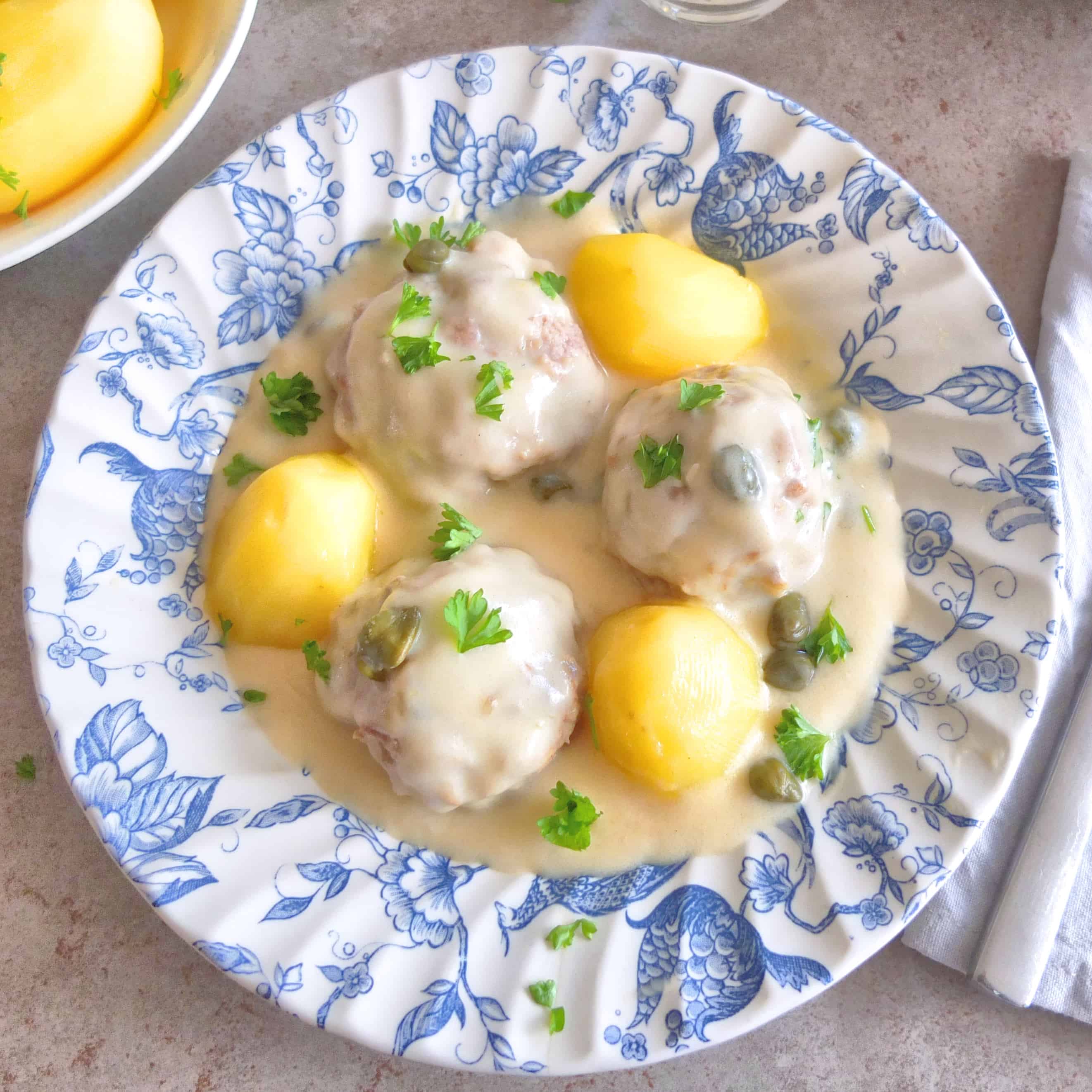 Konigsberger Klopse on a blue plate with potato