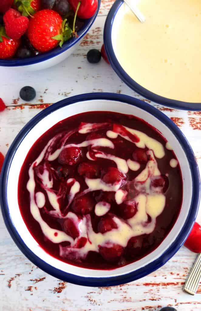 Rote Gruetze with Vanilla Sauce in the Background a bowl of berries 