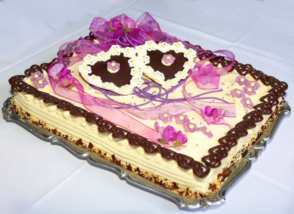 German Wedding Cake  with butter cream. Decorated with two chocolate hearts and some purple ribbon. 