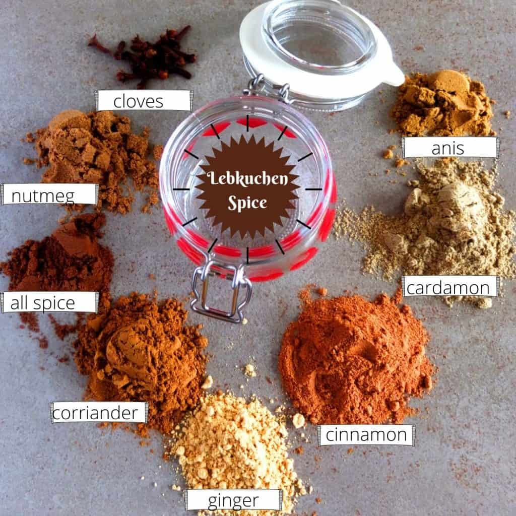 Lebkuchen Spice. A jar in the middle around it are heaps of ground spice. 