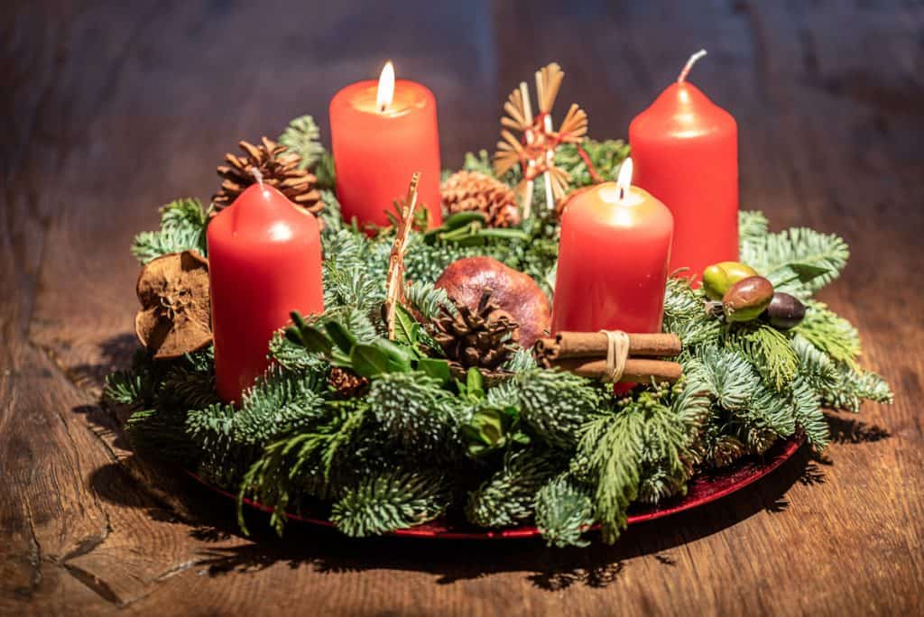 Advent Wreath on a wooden surface with red candles 
