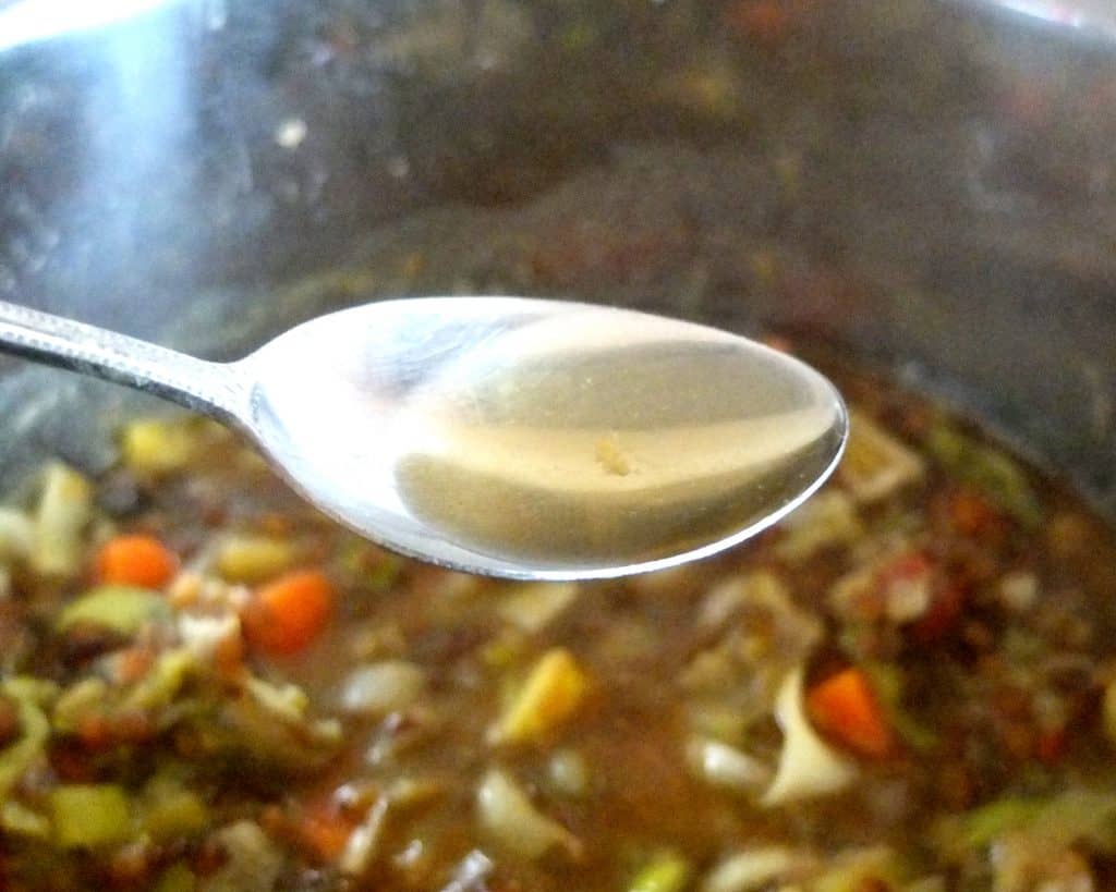 adding a spoon of vinegar to lentil soup