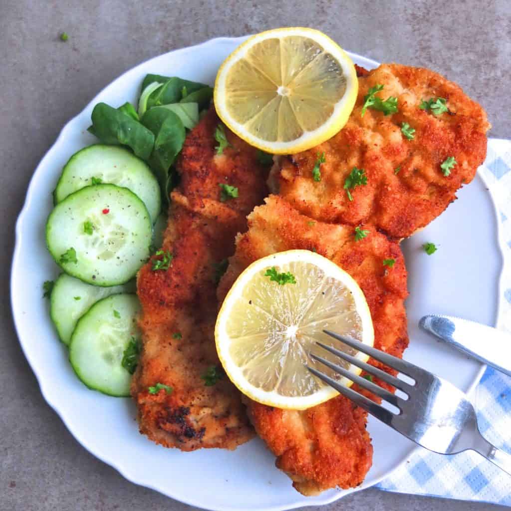 German Schnitzel with cucumbers and lemon slices.