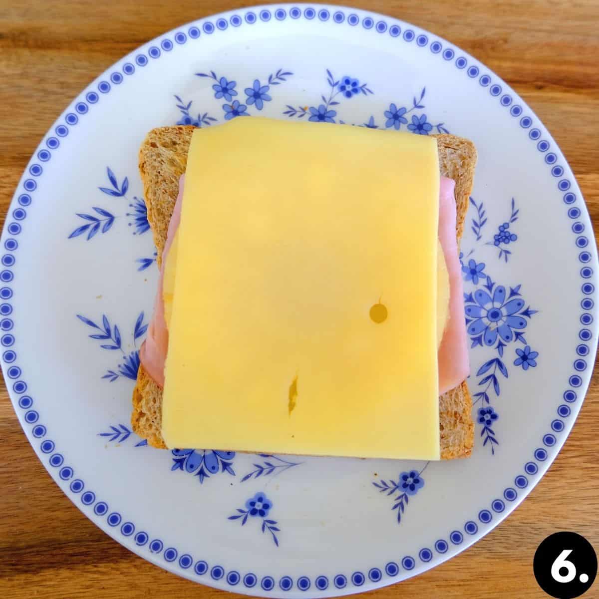 Piece of toast with ham, cheese and pinapple.