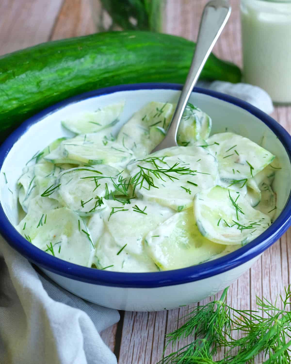 a bowl of cucumber salad german with sour cream.