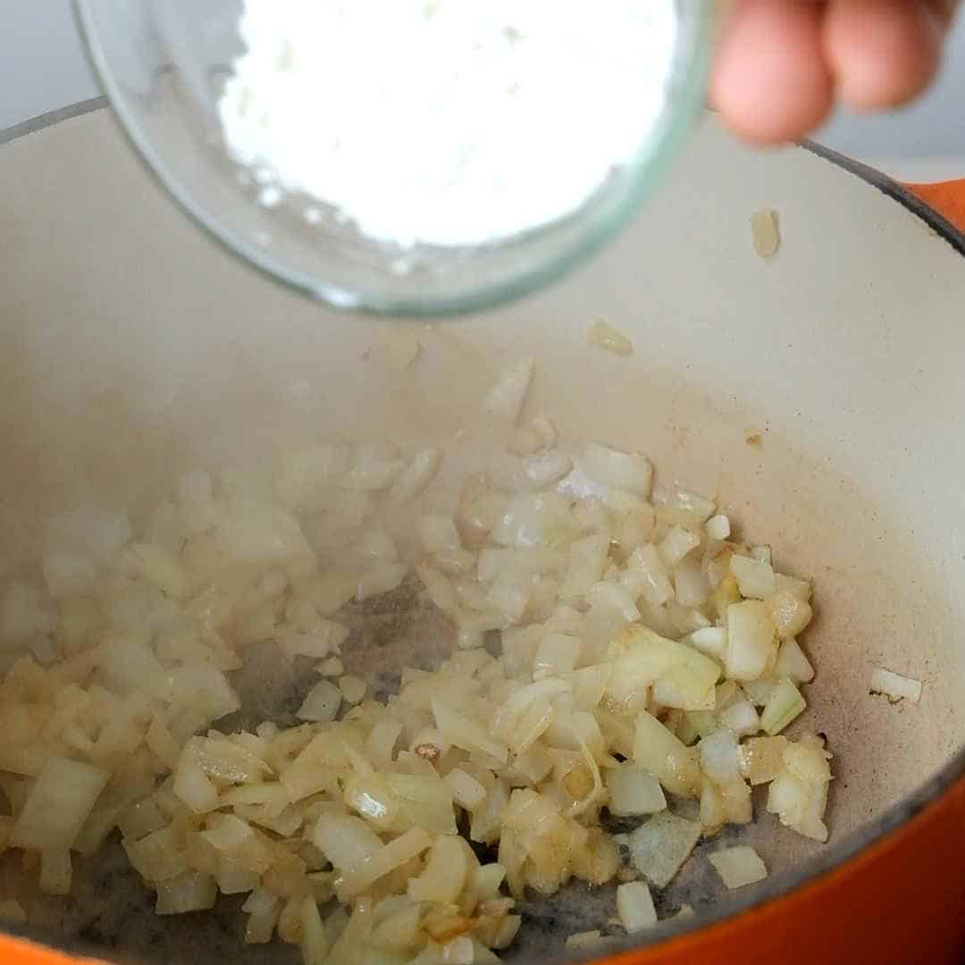 adding flour to onions