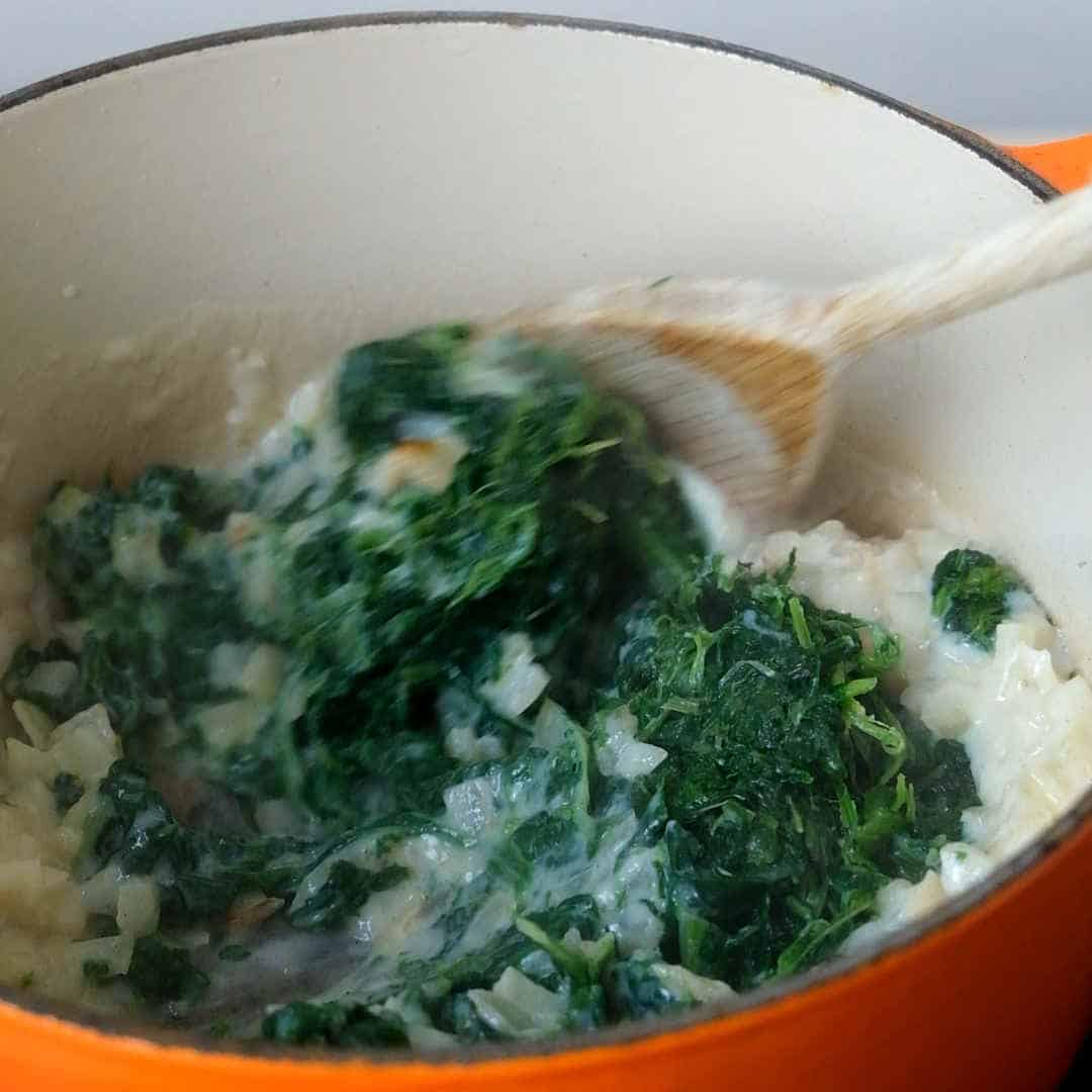 mixing in the spinach into the roux