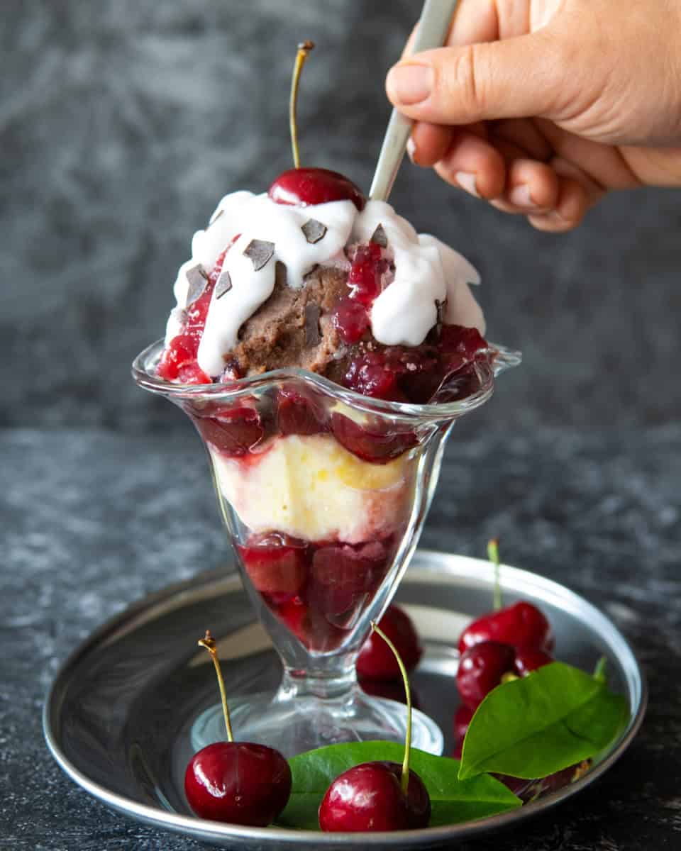 A strawberry sundae with whipped cream and strawberries.