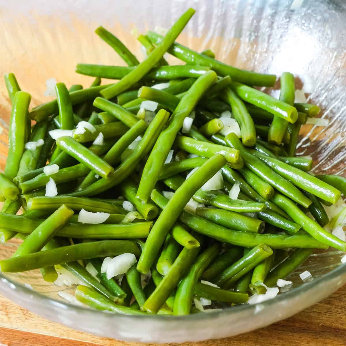 tossing the green beans in the vinegarette