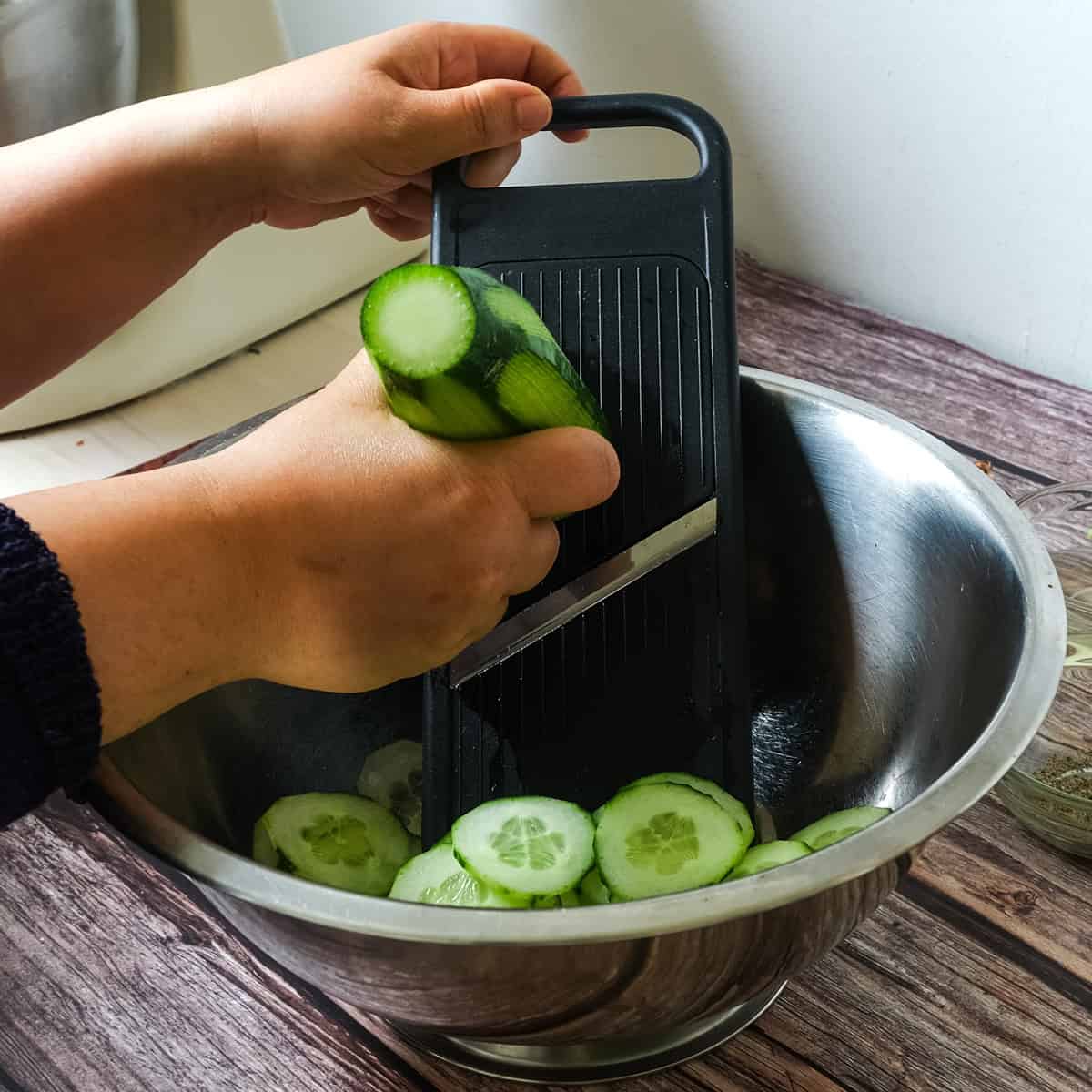 Slicing the cucumbers with a mandolin