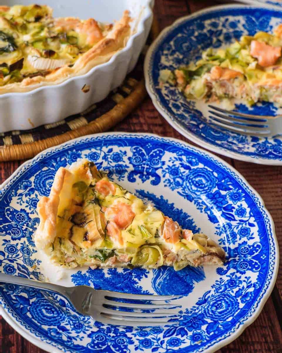 A slice of Salmon Quiche on a blue plate