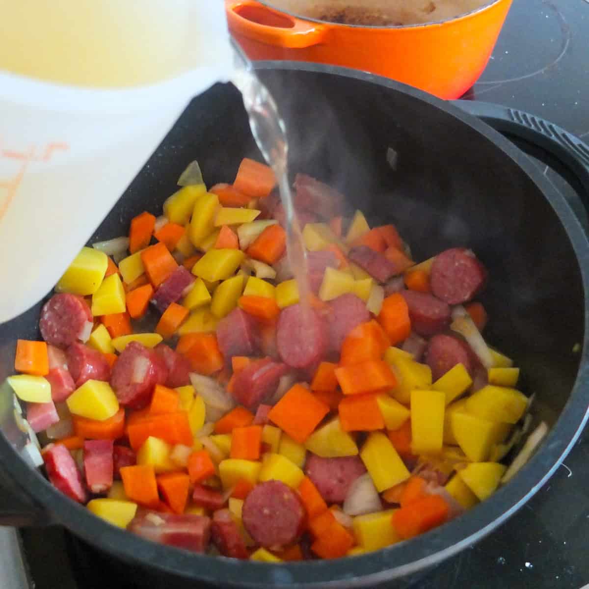 adding broth to bean stew