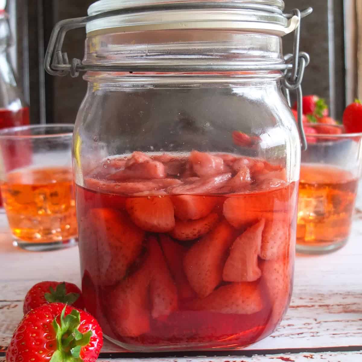 Jar half empty with pale strawberries (infusing/ready)